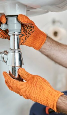 plombier qui contrôle le tuyau d'un lavabo