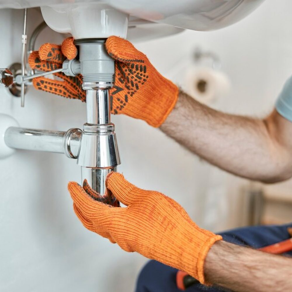 plombier qui contrôle le tuyau d'un lavabo